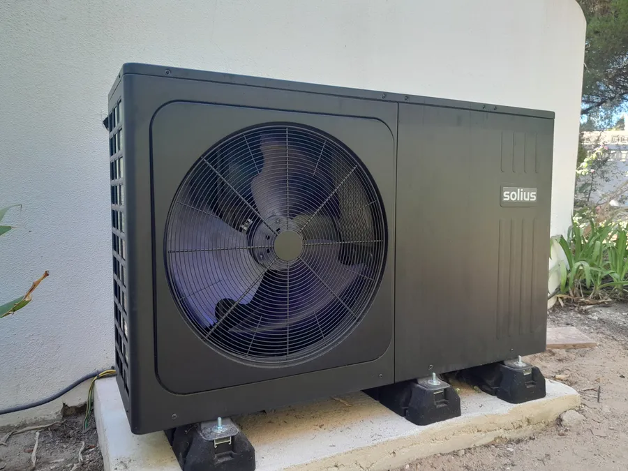 An air source heat pump installed outside a villa, connected and ready to commission