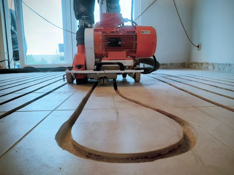 Milling machine cutting a channel into an existing tiled floor