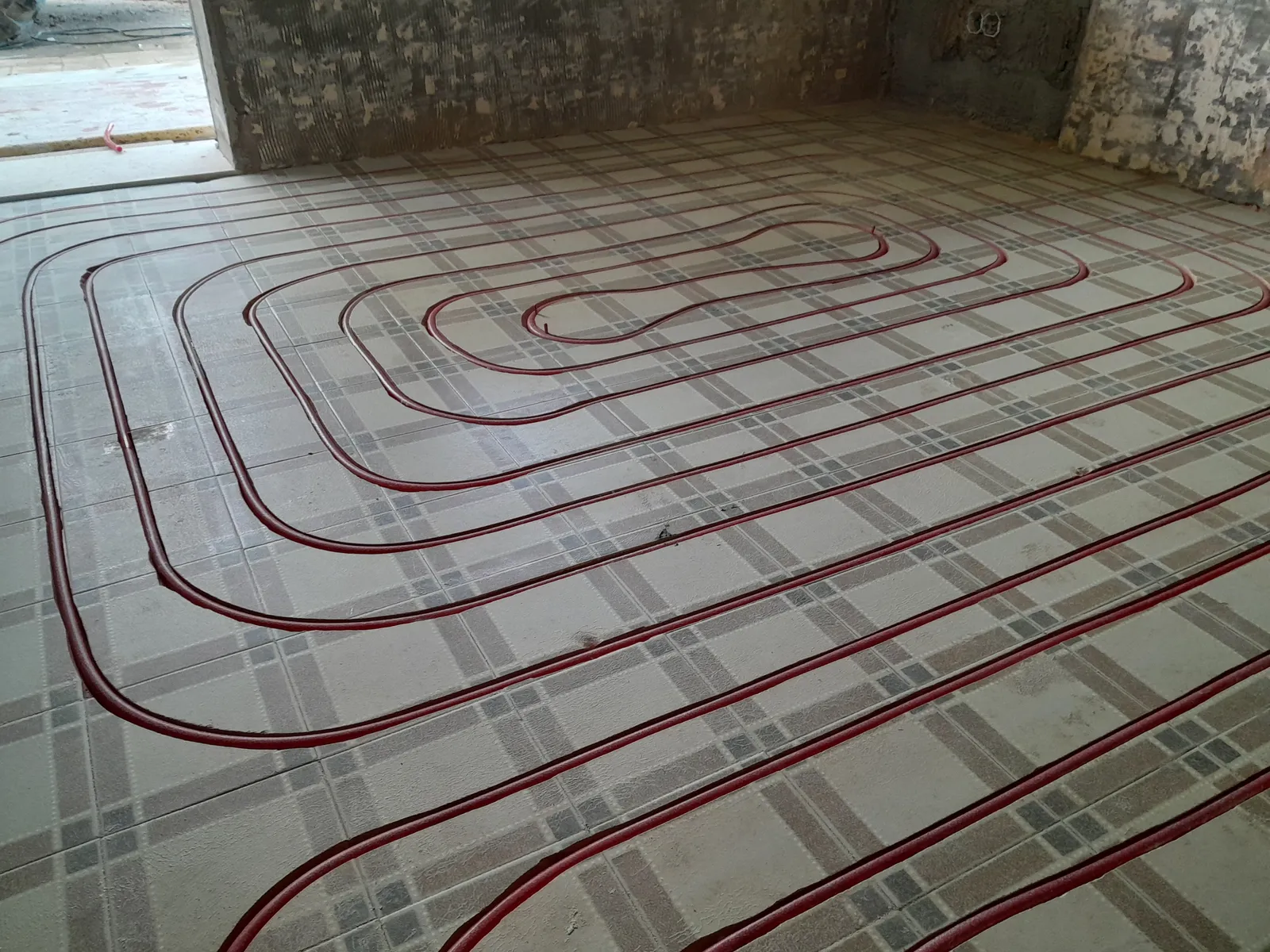 Heating pipe milled into an existing patterned tile floor across a full room