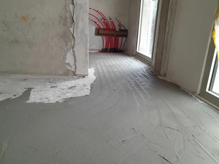 Pipes fanning out from a manifold into an opened subfloor