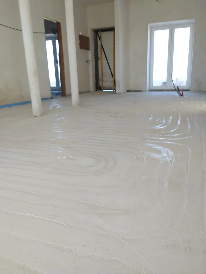 Screed being finished over freshly laid heating pipe
